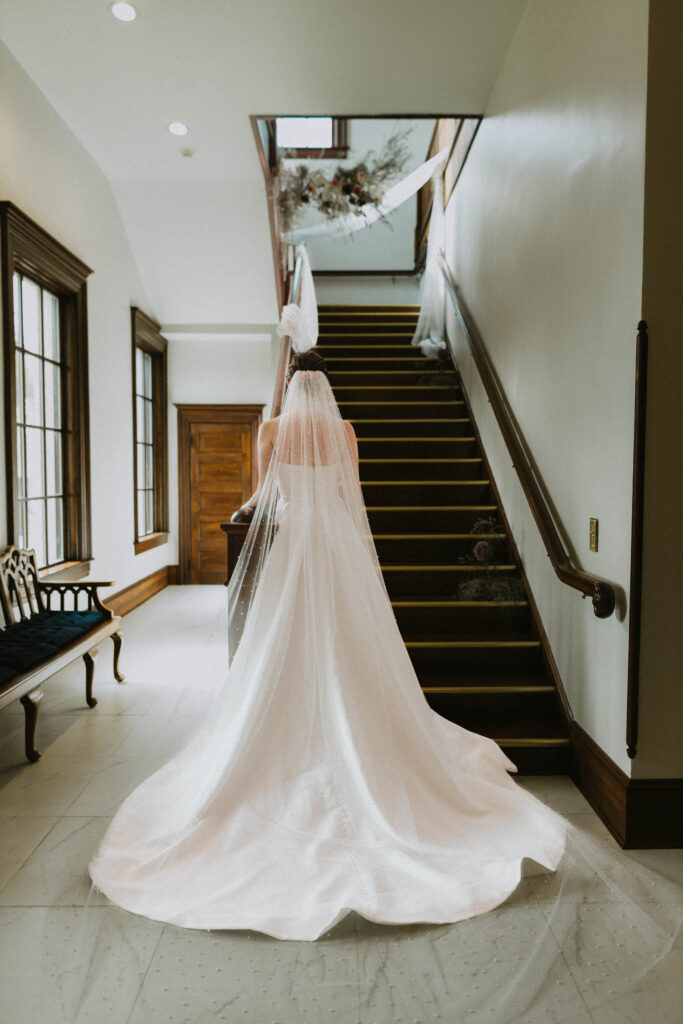 Bride goes up the staircase at 1908 Grand to meet her Groom to be for their First look on their wedding day