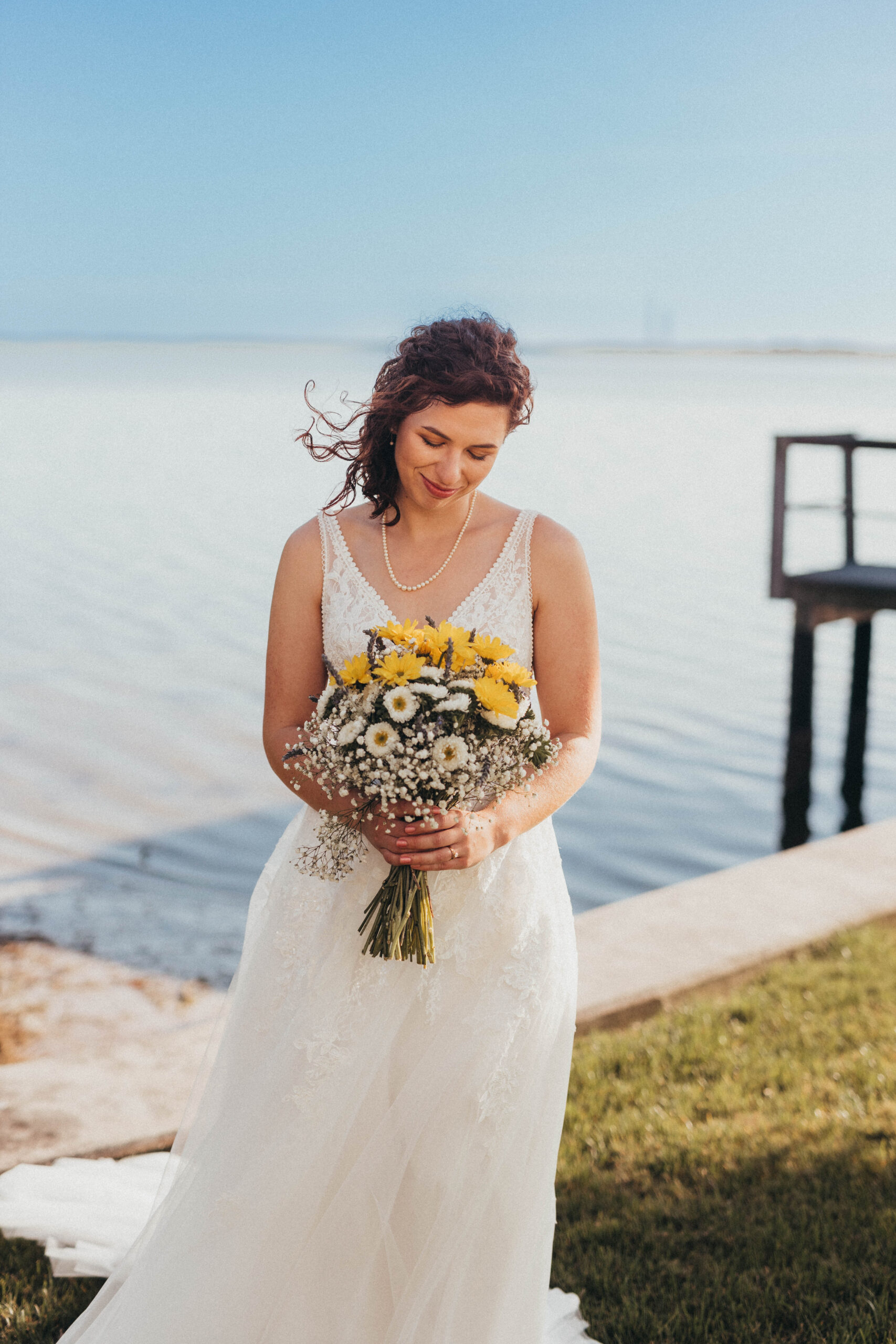 Bride standing by the ocean at Wedding Venue Tampa Bay Watch for her wedding day in Tampa, Florida