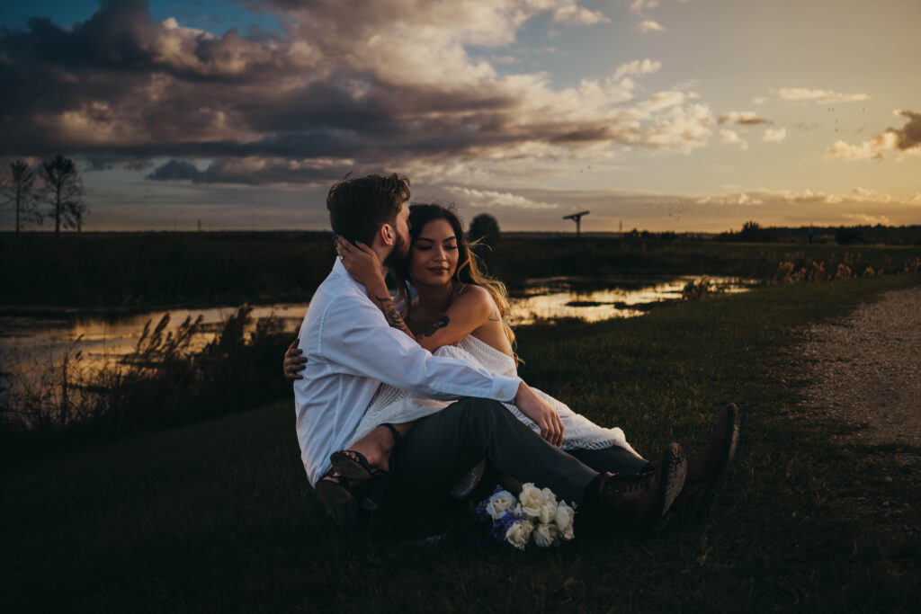 bride and groom sitting with each other by a pond at Sweetwater wetlands in Gainesville, Florida